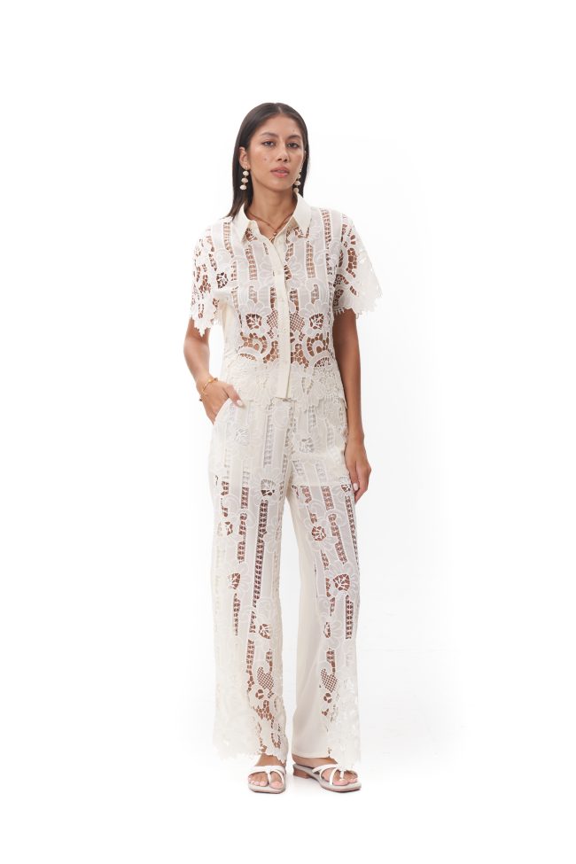 Maribel Lace Top The Maribel Lace Top features a classic collared neckline with a button-front design and short sleeves. Crafted in intricate floral lace with delicate scalloped edges, it offers a refined yet feminine look. Lightweight and breathable, this top is perfect for styling with the matching Maribel Lace Pants or wearing on its own for elevated daytime wear.
