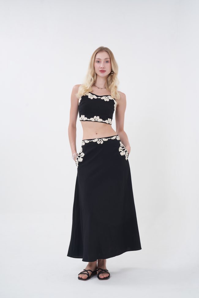 Minimal with a romantic twist, the Liora top is designed to feel effortlessly elevated. Its clean, structured silhouette is softened by delicate lace edging along the neckline and hem, creating a subtle yet eye-catching contrast. The cropped length highlights the waist while keeping the look fresh and modern—perfect for pairing with its matching skirt or styling with your favorite high-waisted pieces for an easy day-to-night transition.